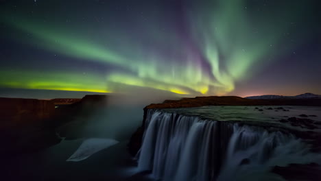 spectacular northern lights over a waterfall in iceland