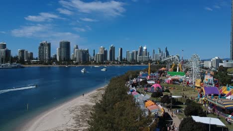 vista aérea de un colorido carnaval situado junto al mar con el horizonte de la ciudad al fondo