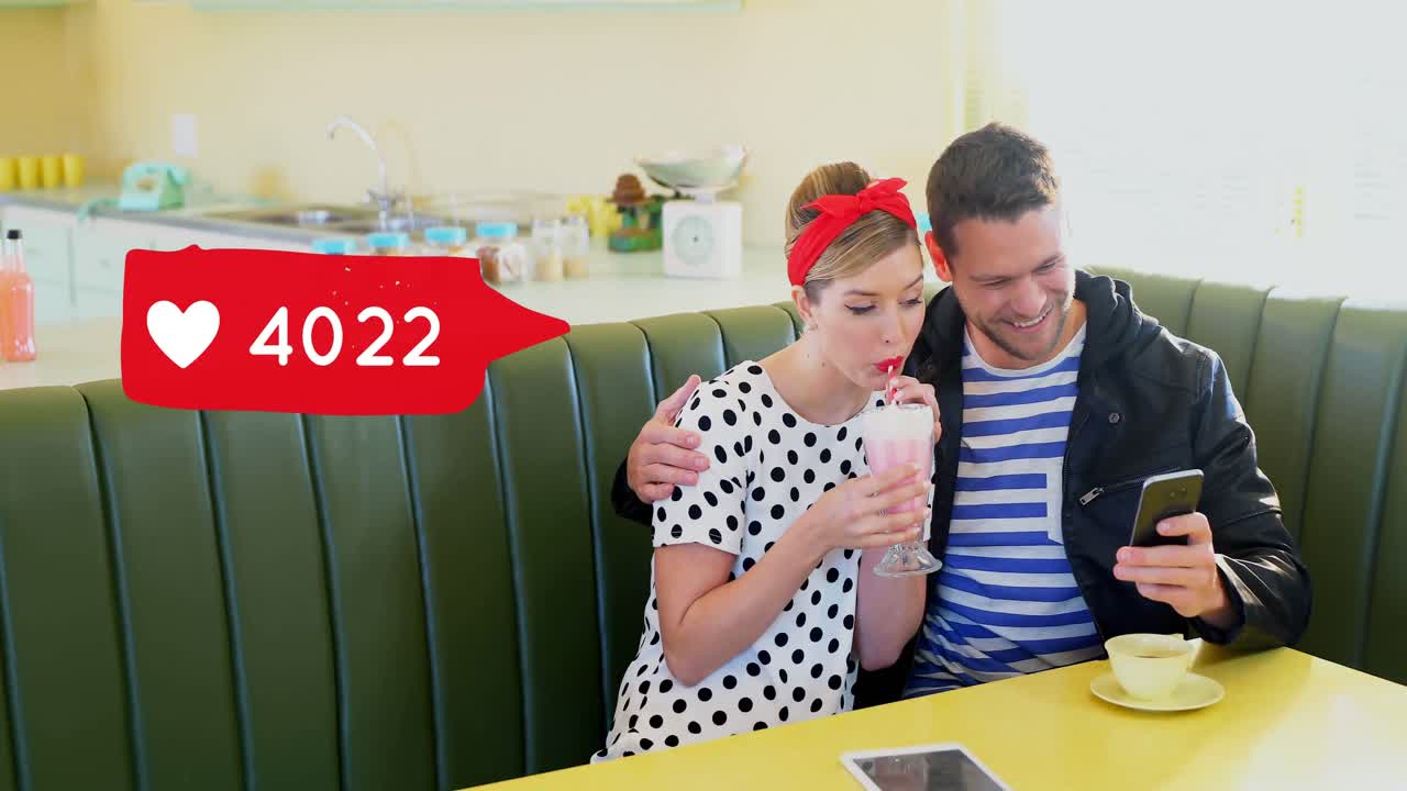 pareja sentada en una mesa de cena compartiendo un batido de fresa 4k