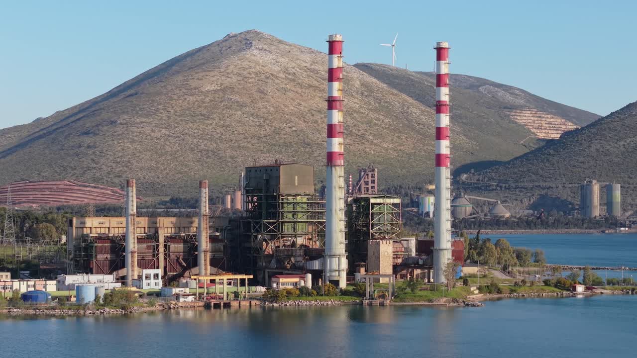 Una ripresa aerea ascendente con drone rivela la centrale elettrica di Aliveri lungo la costa di Evia, mettendo in mostra la sua scala industriale e la sua posizione sul mare