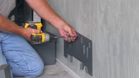 técnico usando un taladro para instalar el soporte colgante para los soportes de la caja de la batería