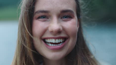 portrait-happy-young-woman-laughing-feeling-joy-outdoors-by-lake-4k