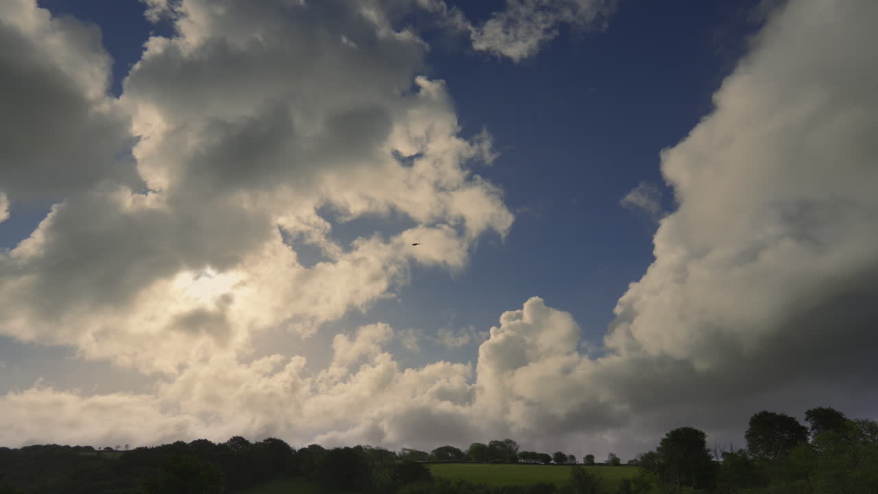 Morning Timelapse with Sun Flare Behind Light and Dark Clouds Passes Across Blue Sky. High Quality Nature Weather Footage.