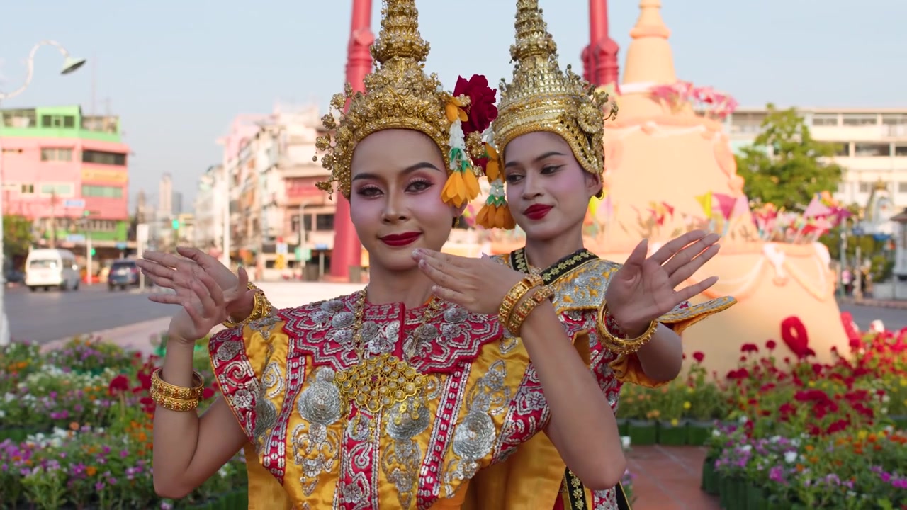 Due ballerine thailandesi in costumi tradizionali si esibiscono all'aperto