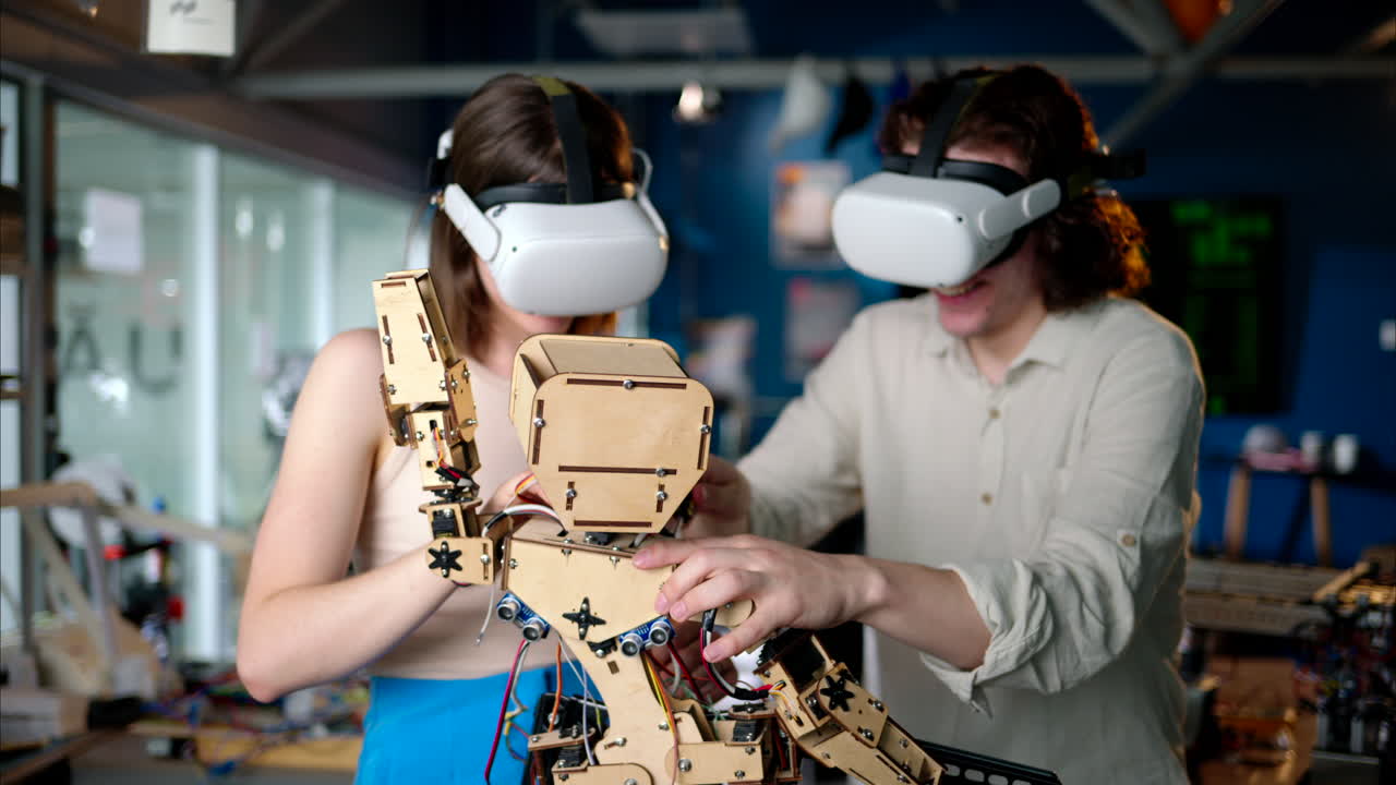 Two young engineers fixing a mechanical robot in the workshop, using VR virtual reality headsets
