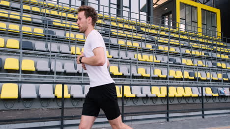 sportive man running fast in the stadium