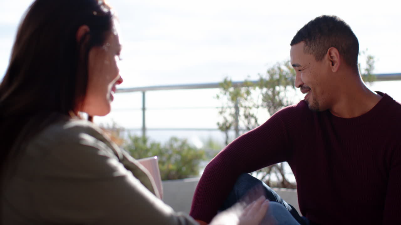 Sitting outdoors, couple talking and holding hands, enjoying time together