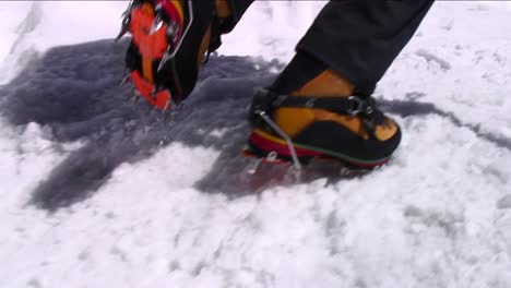 crampons digging into snow as climber ascends