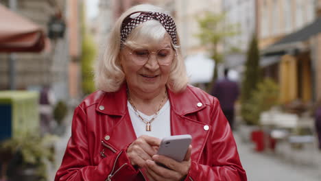 mujer anciana usando un teléfono inteligente escribiendo mensajes de texto buscando un camino en el mapa en la aplicación de navegador móvil