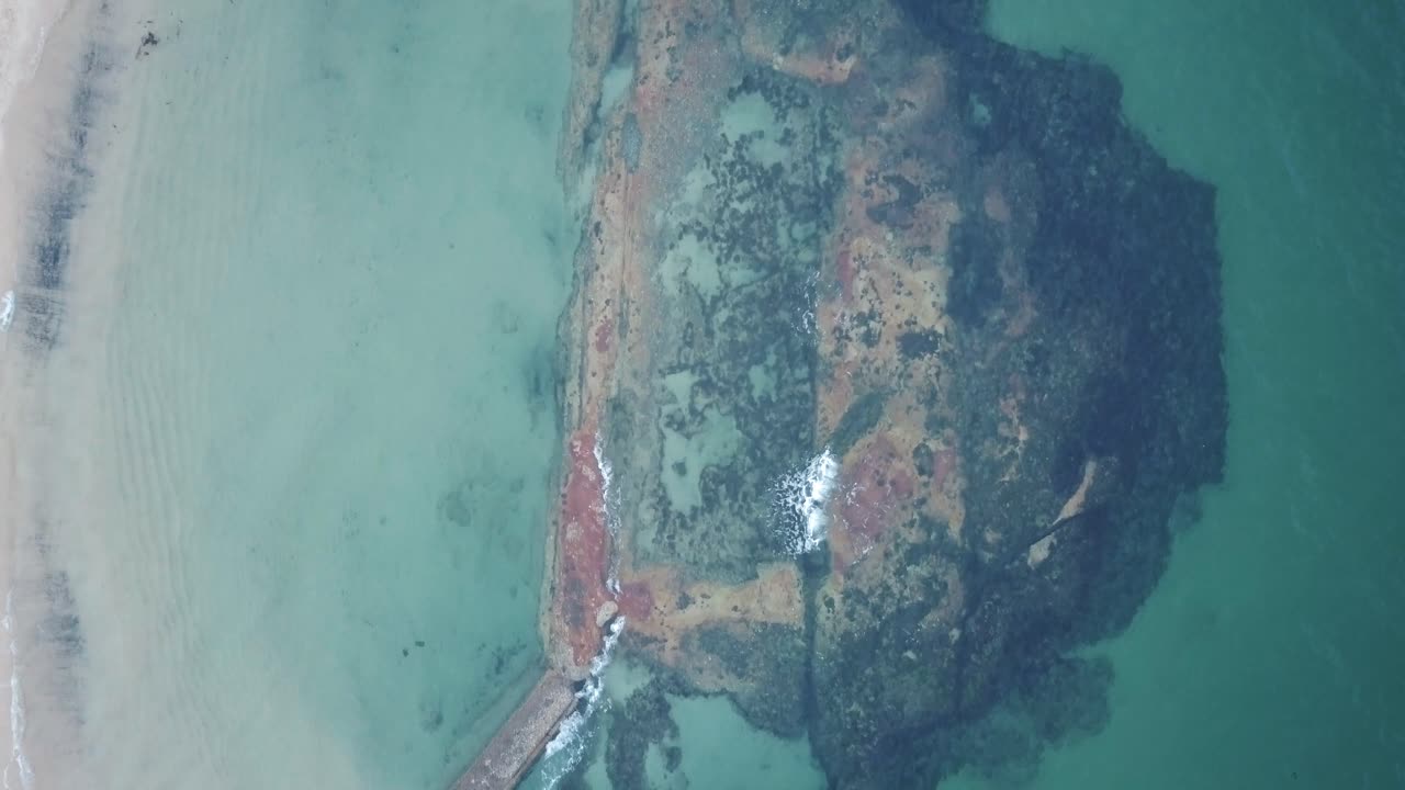 vista panorámica de una enorme roca bajo el agua en la playa de balmoral en sydney, nueva gales del sur - drone aéreo, de arriba hacia abajo