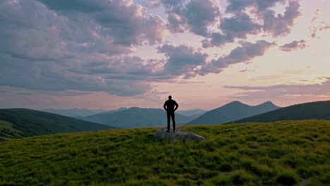 man standing on a mountaintop at sunset