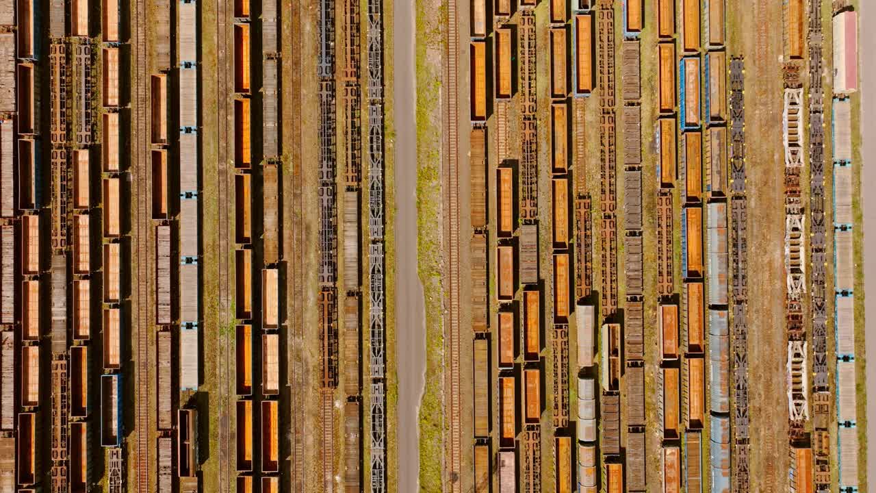Rusty freight trains abandoned on parallel tracks creating industrial pattern