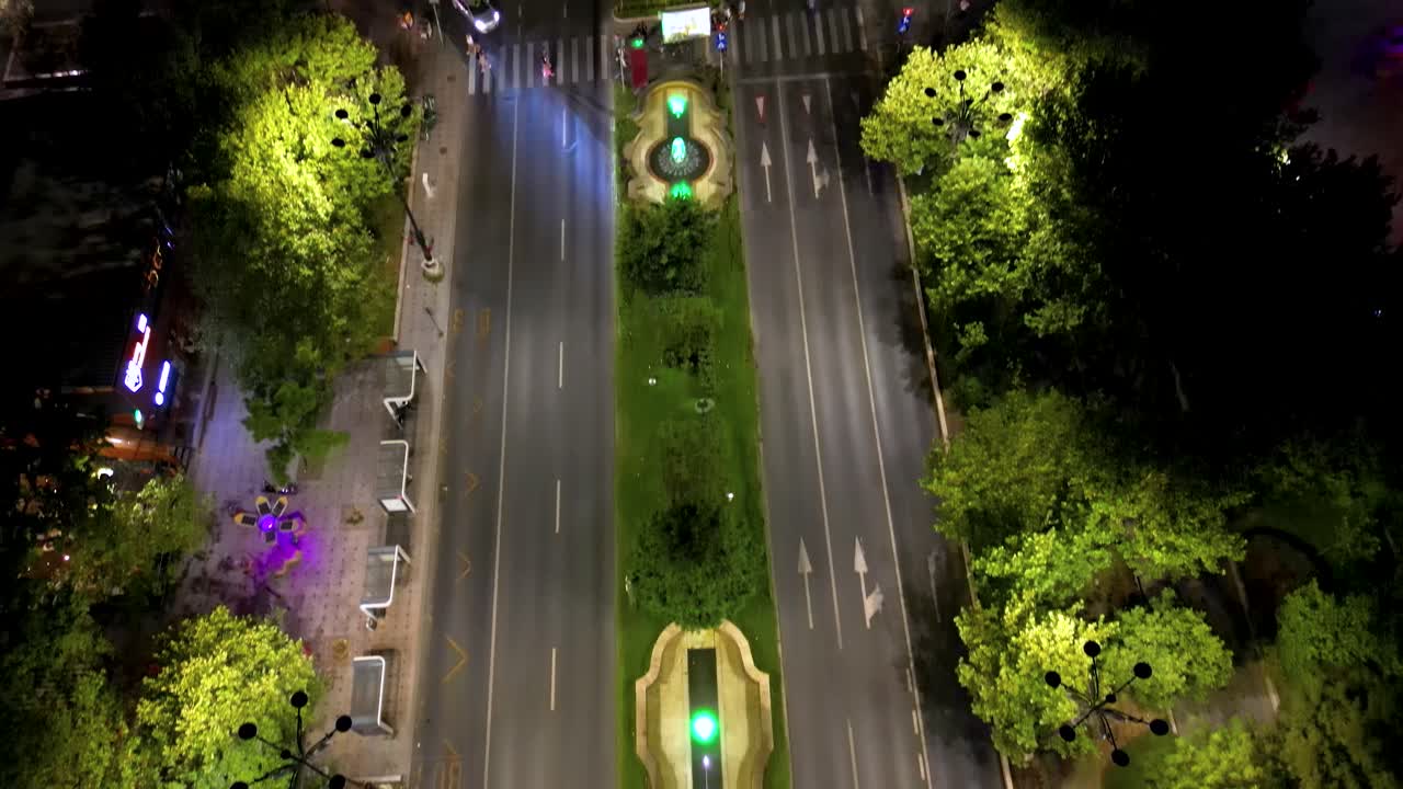 Aerial footage of city center of Bucharest, at night. View of Unirii Bulevard. Water fountain. Capital city of Romania. Famous travel destination. Camera tilt up. Night traffic.