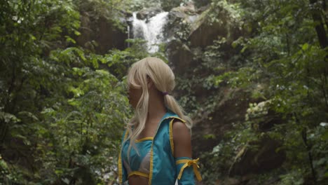 epic waterfall flowing over a cliff with an anime cosplayer turning around to look at it