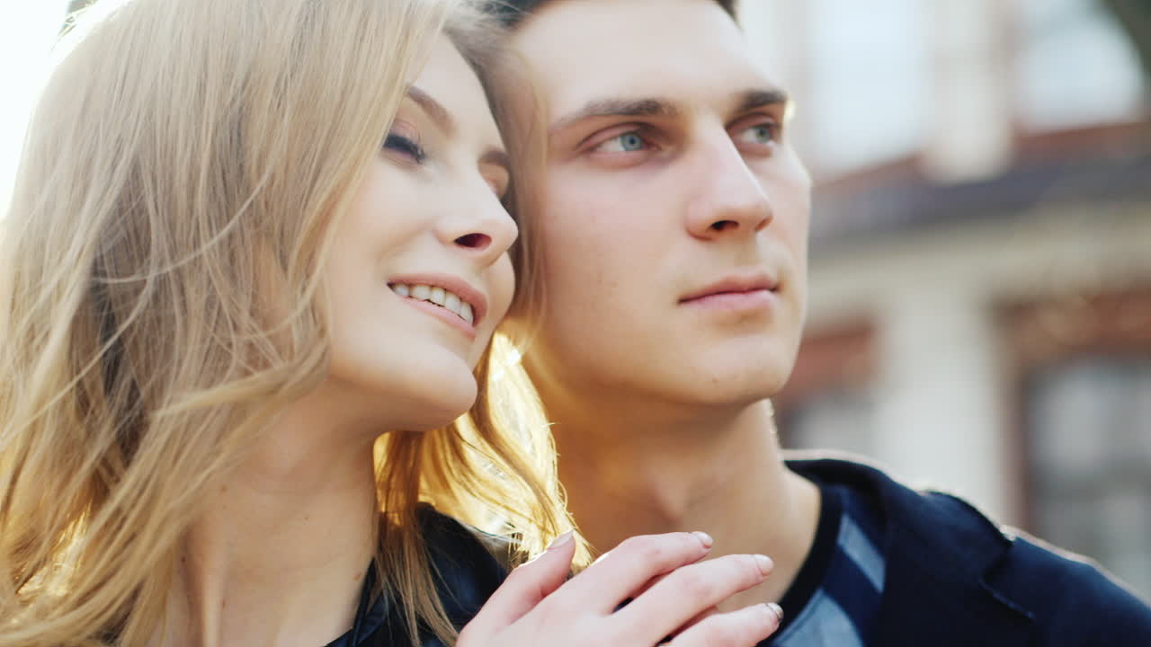 남자와 여자는 태양에 의해 아름답게 빛나는 그들의 머리를 미소 짓고 있다