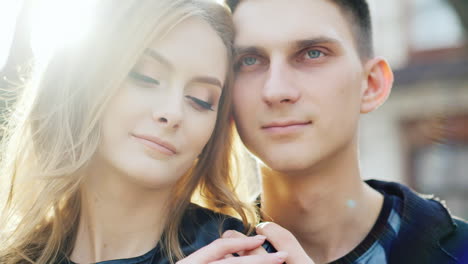 man and woman embracing smiling their hair beautifully illuminated by the sun