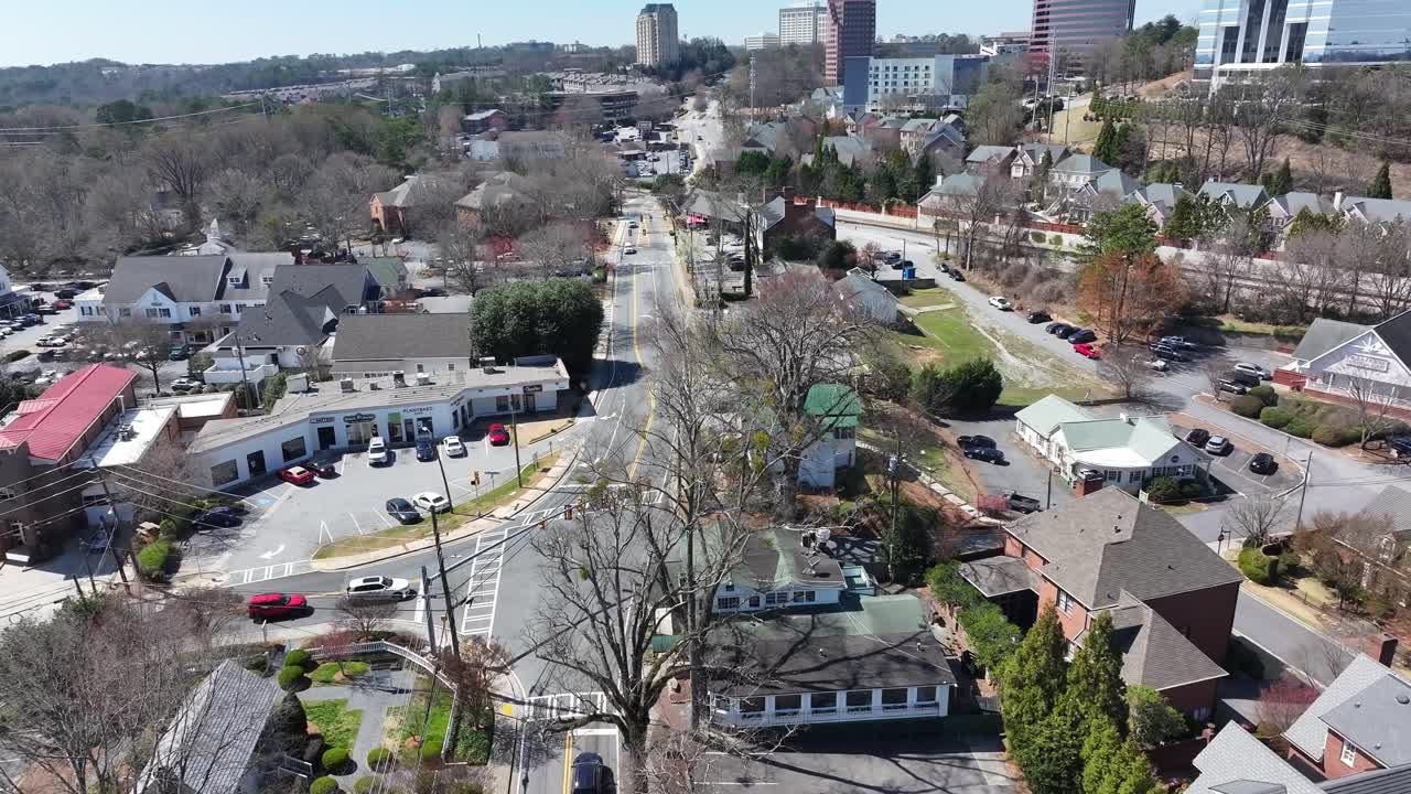 Vinings village in sunny daylight surrounded by urban park trees, Paces Ferry Road intersection, Atlanta, Georgia, Drone