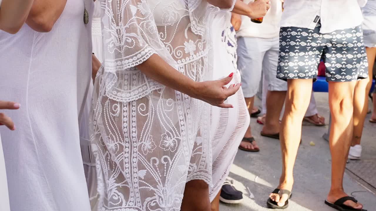 야트의 갑판에  ⁇  옷을 입고 춤을 추는 다양한 친구들의 그룹