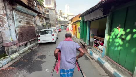 rickshaw puller on a narrow street in kolkata, india