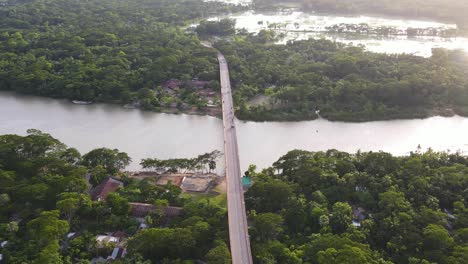 aerial high view bridge connecting forested riverbanks, wetlands in background