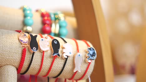 red string bracelets with fish and elephant charms