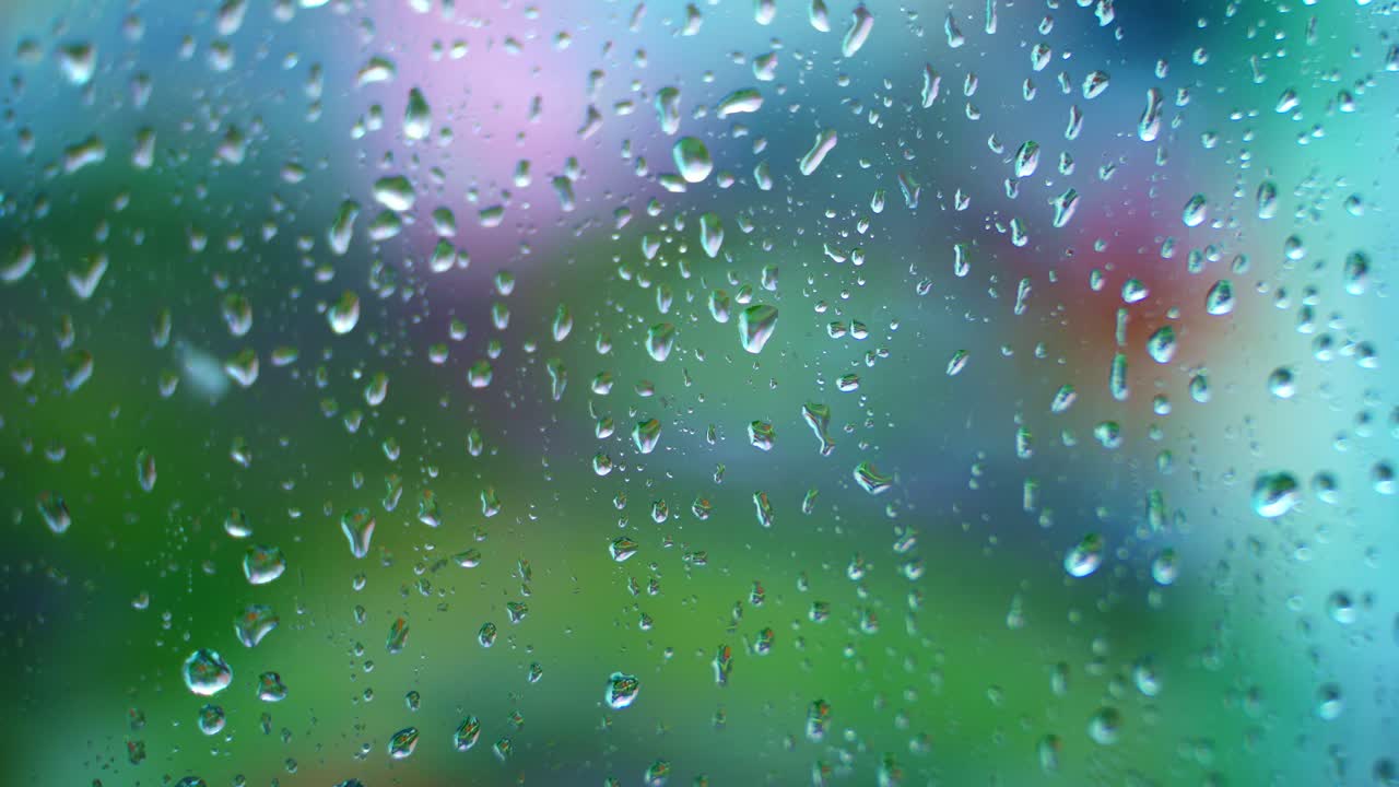 Glass background with raindrops. Water drops flowing on window surface with blur moving dots outside. Close-up.