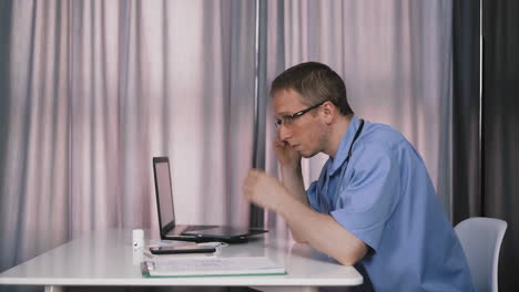 young-doctor-sits-at-table-near-window