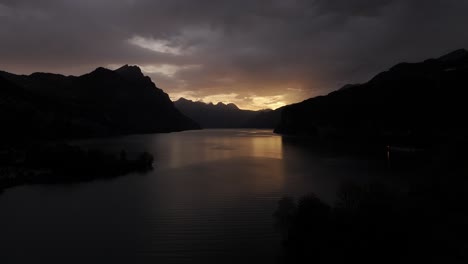 dusk settles over switzerland's walensee lake, as evening darkness slowly descends. a tranquil scene capturing the quiet transition from day to night in serene, natural beauty.