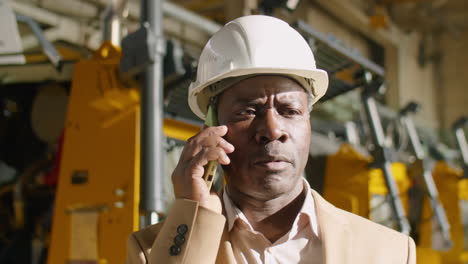 african american engineer talking on phone in factory