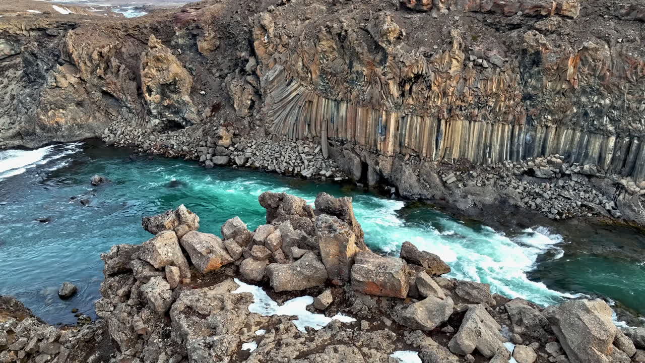 Aerial view tilting over rocks, toward the Aldeyjarfoss rapids, spring in Iceland