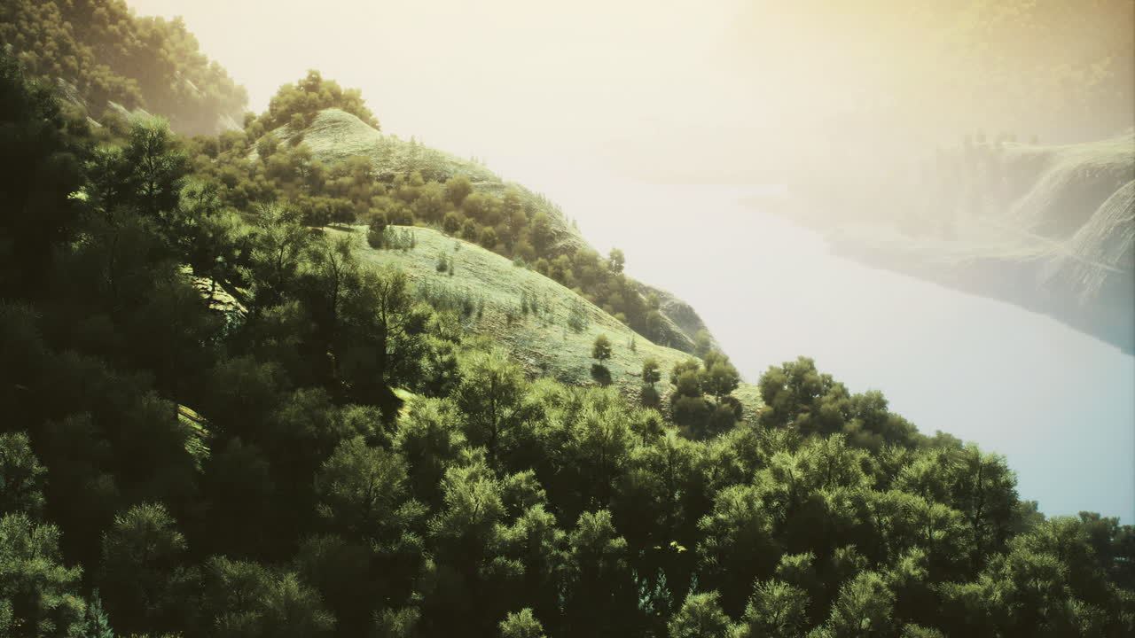 Lush green hillsides embrace the tranquil waters beneath a glowing sky