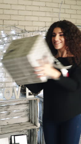 new year presents concept. woman opening her new year gift boxes while lying at home vertical video