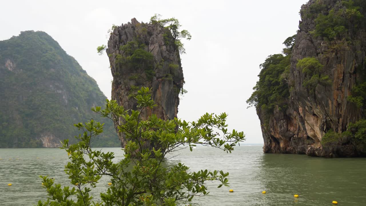 Rock formations on James Bond Island in Thailand surrounded by calm waters and lush greenery