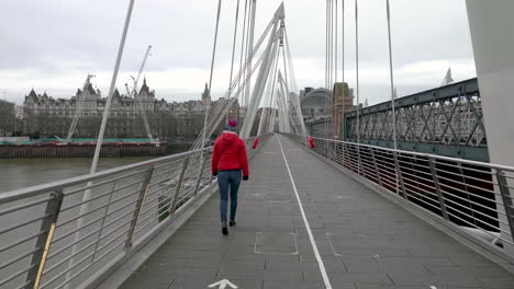 young british women crossing an empty golden jubilee bridge during the covid19 pandemic, london