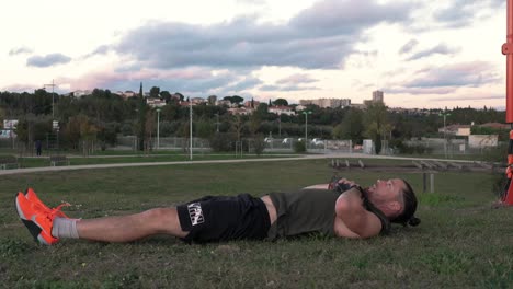 a muscular sportsman does abs while reaching for his feet