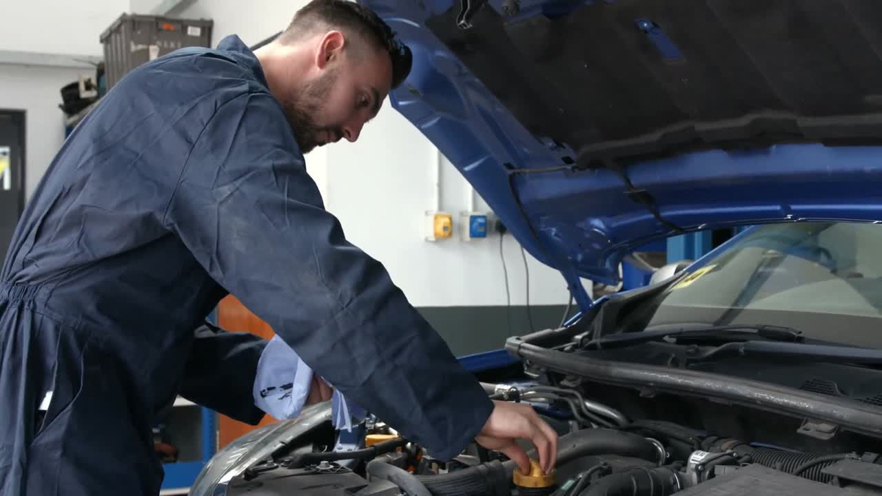 mecánico comprobando el aceite en el motor