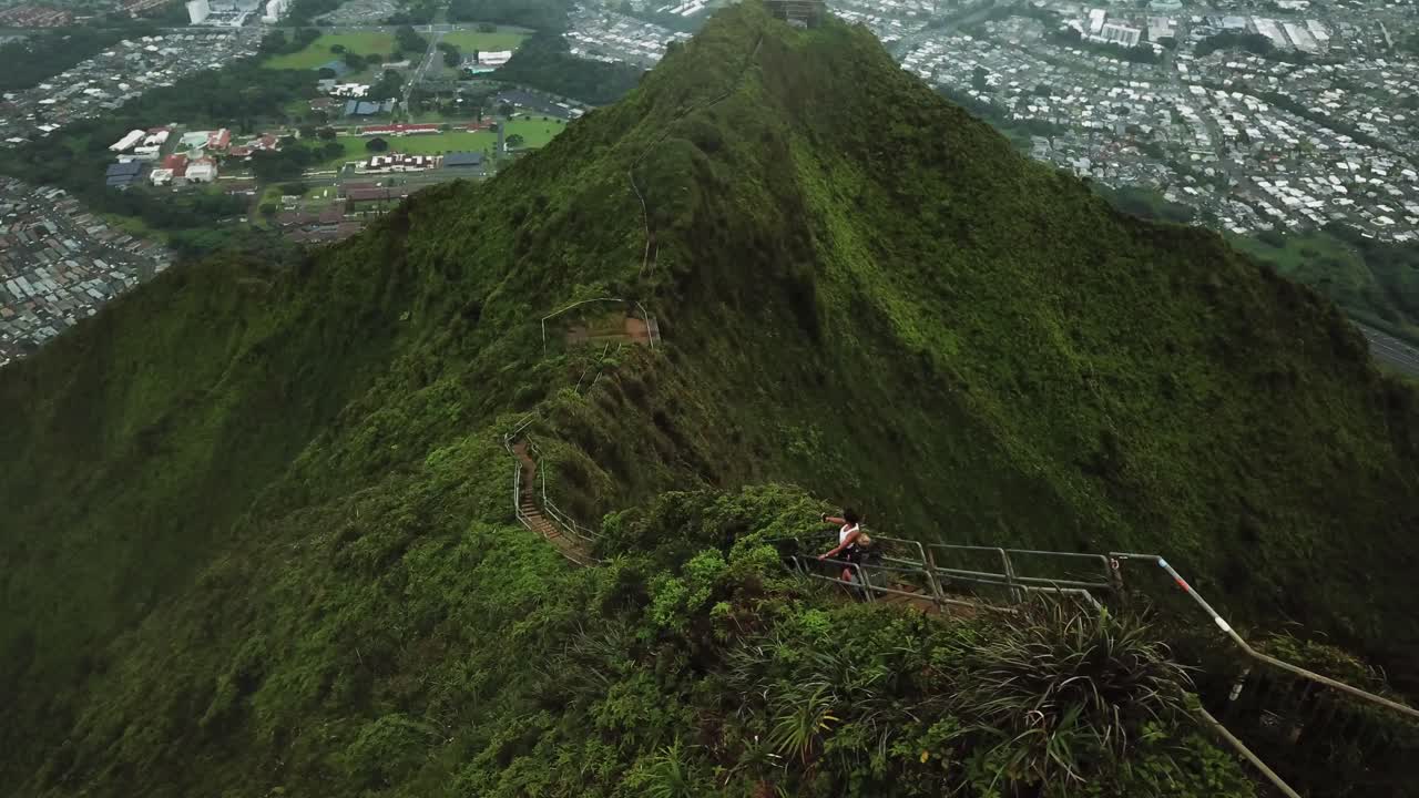 Aerial view of hikers on the Haiku Stairs Trail, or Stairway to Heaven. Kaneohe City, Oahu can be seen at the bottom of the mountain.