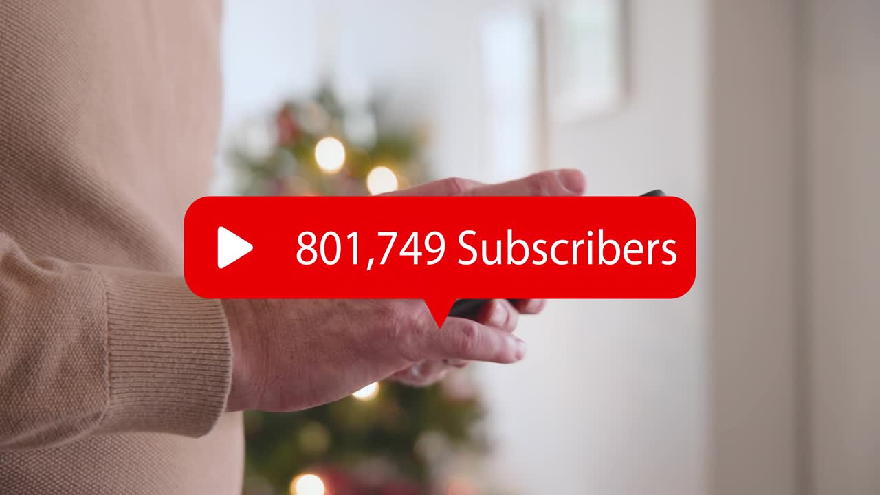 Man tapping phone by Xmas tree, red sub count overlay rising over screen, tracking channel growth