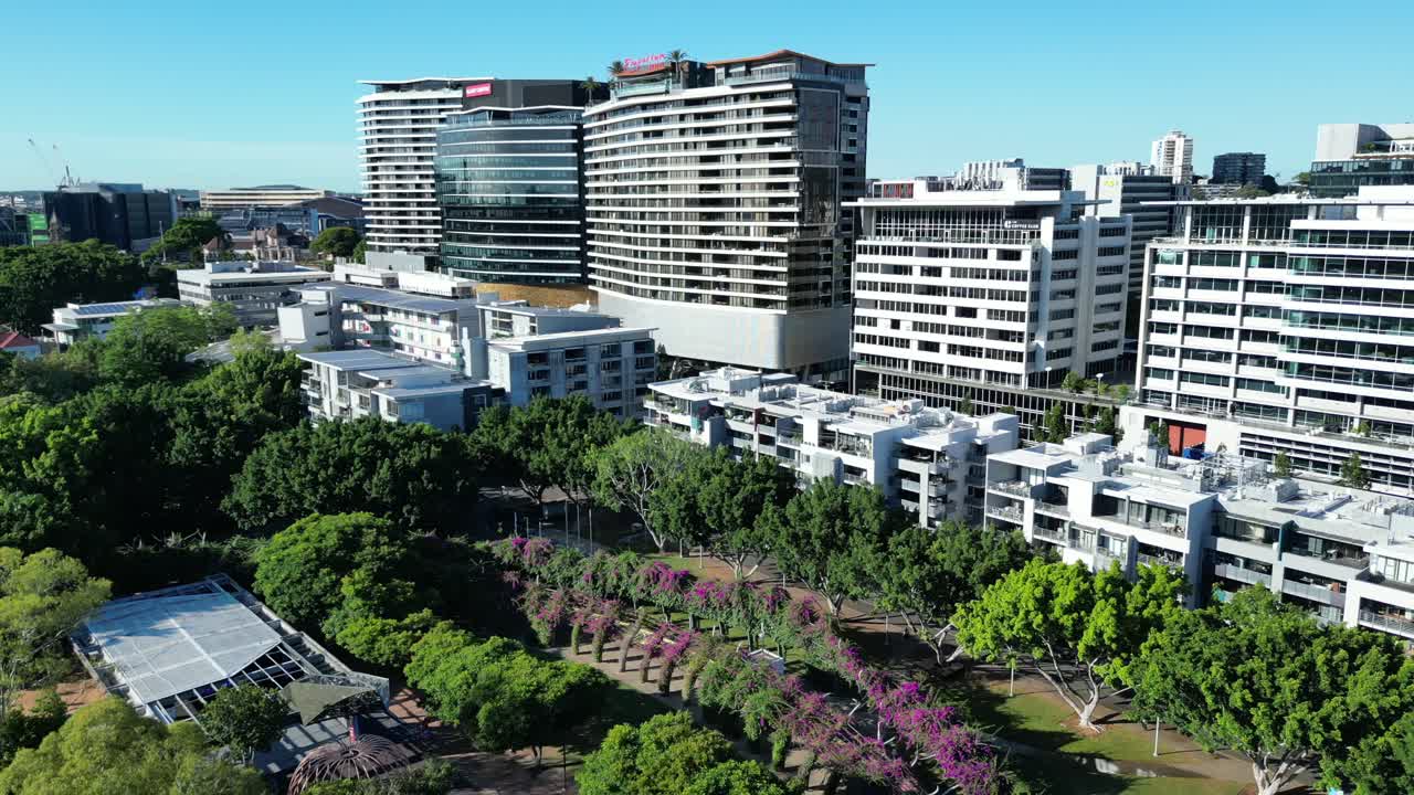 공원과 많은 아파트 건물을 배경으로 브리즈번 사우스 뱅크 파크랜드의 회전 드론 샷