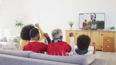 video of african american family sitting on the couch and watching football match