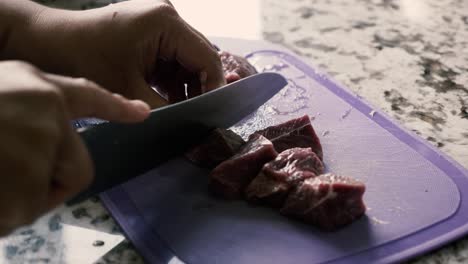 cutting red meat on chopping board