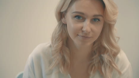 portrait of young blonde woman looking at camera indoor