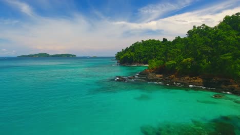 forward aerial flight edge of coral rocky island revealing secret beach