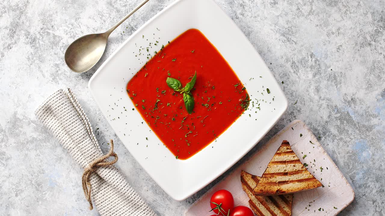 sopa de tomate rojo con pan crujiente y cuchara