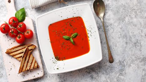 Red-tomato-soup-with-crisp-bread-and-spoon