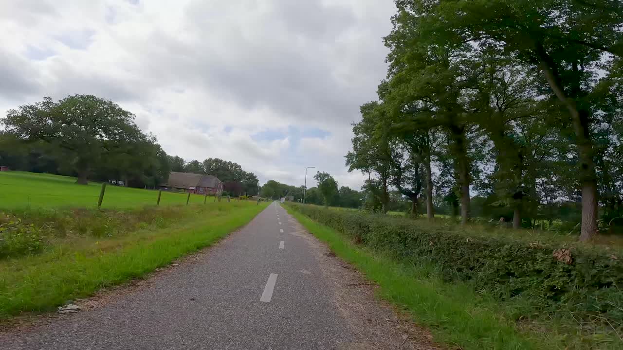 POV-cykeltur langs en landlig cykelsti gennem grønne marker