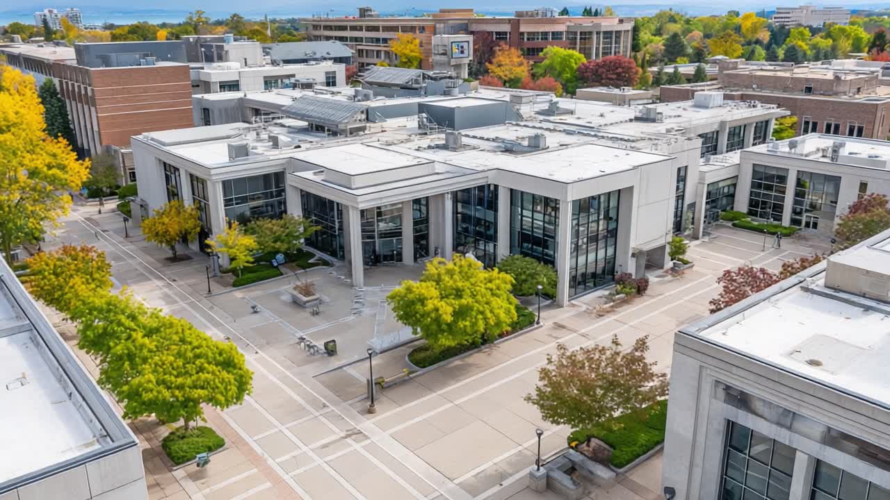 Aerial View of Modern Campus Architecture Surrounded by Colorful Fall Foliage and Greenery, Showcasing Open Spaces and Urban Landscape Design