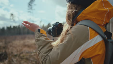 mujer fotógrafa revisando con su mano si la lluvia se detuvo y toma algunas fotos con su cámara de fotos digital