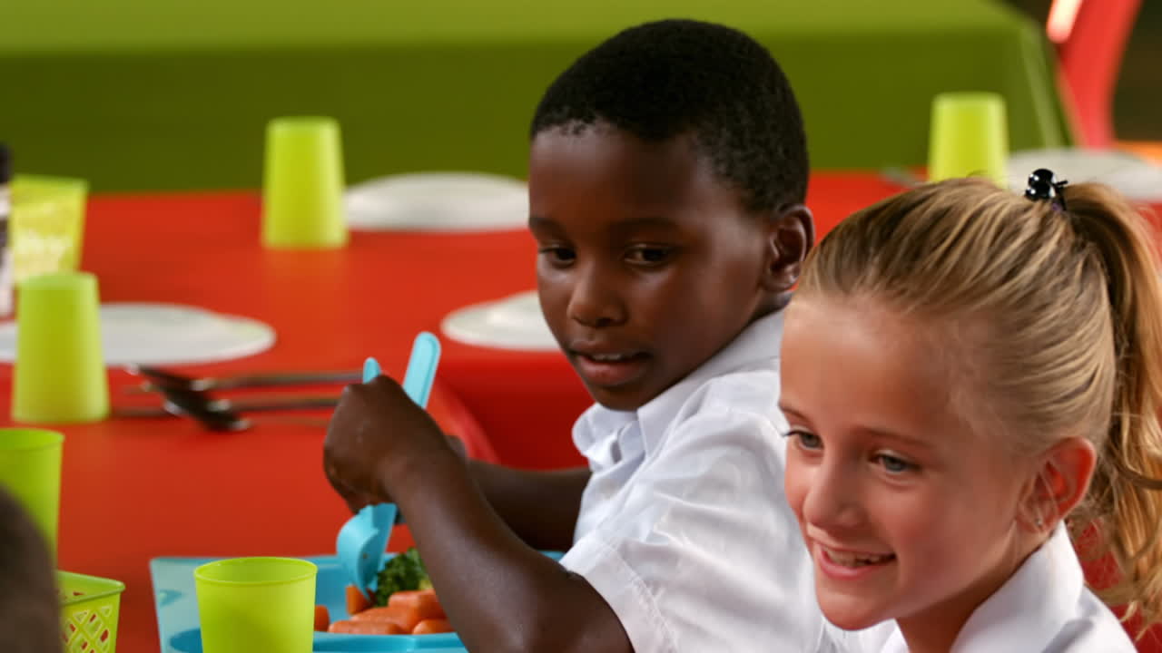 niños interactuando mientras comen en la cafetería