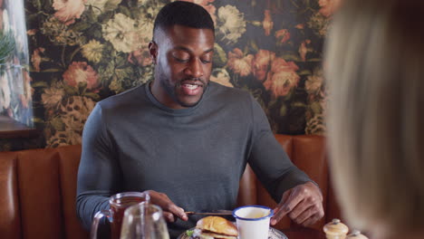 couple eating in restaurant of busy traditional english pub